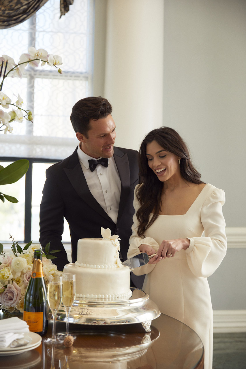 Bride and groom slicing cake at wedding venue in Charleston.